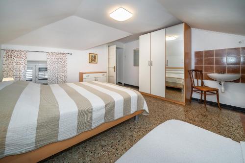 a bedroom with a bed and a bathroom with a sink at Studio Apartments Cavrak with Terrace in Baška