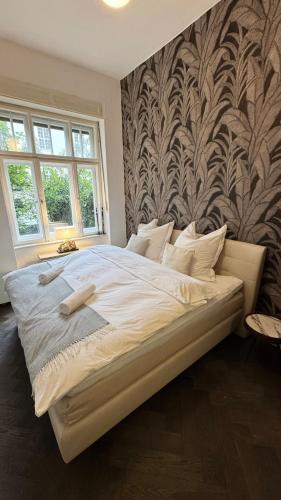 a large bed in a bedroom with a wall at Exklusive Wohnung im Herzen Münchens in Munich