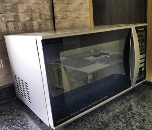 a microwave oven sitting on top of a counter at The Perfect Living Lavish Flat- for Families only in Nashik