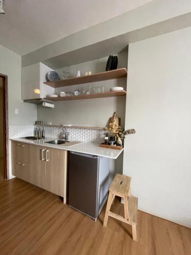 a kitchen with a counter and a wooden stool at Coastal Vibe Studio in Cebu City