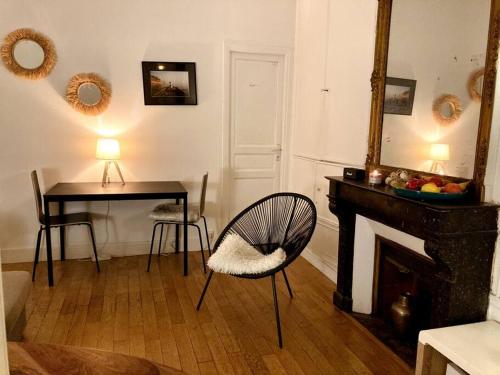 un salon avec une table, une chaise et un miroir dans l'établissement Paris 9e bel appartement de 40m2, à Paris