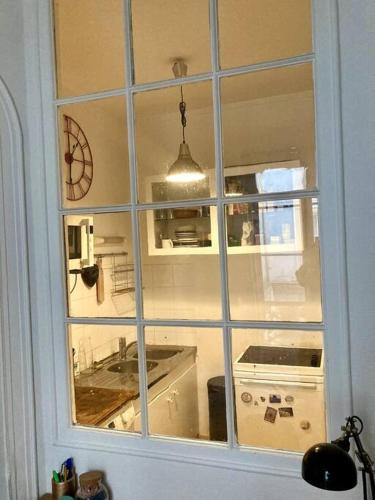 - une fenêtre dans une cuisine avec évier dans l'établissement Paris 9e bel appartement de 40m2, à Paris