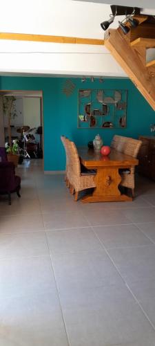 a dining room with a table and a blue wall at A Larriou in Mirepoix