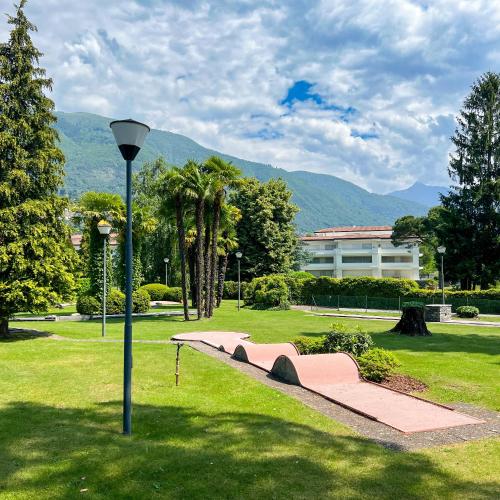 a park with a bench and a light pole at Delta Resort Apartments in Ascona