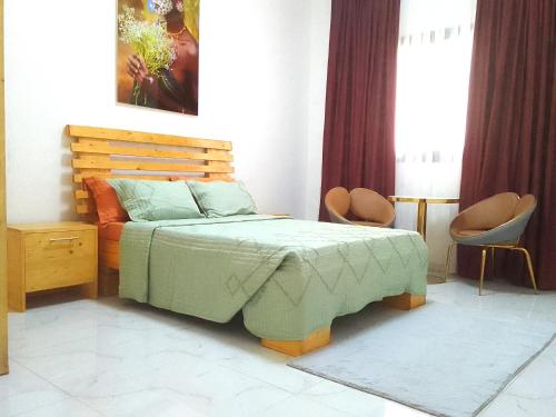 a bedroom with a bed and two chairs at La Rouah Mishkan in Dakar