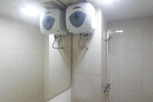 a bathroom with a shower with a camera on the wall at Enchanting Luxurious 2BR Apartment at Tanglin Supermall Mansion By Travelio in Surabaya