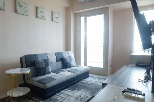 a living room with a couch and a table at Enchanting Luxurious 2BR Apartment at Tanglin Supermall Mansion By Travelio in Surabaya