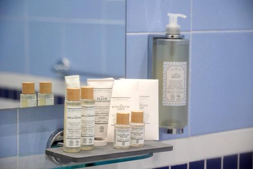 a shelf with four bottles of lotion and a spray bottle at Hotel Villa Adriana in Monterosso al Mare