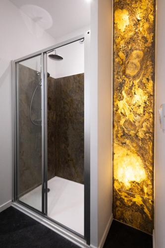 La salle de bains est pourvue d'une douche et d'une peinture murale. dans l'établissement L'Escapade Marcquoise, à Marcq-en-Barœul