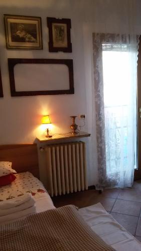 a bedroom with a bed and a window and a radiator at Villa Fiorita in Monfalcone