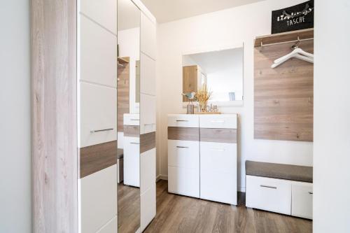 a kitchen with white cabinets and a mirror at Seebreeze 50 2 N in Wangerland