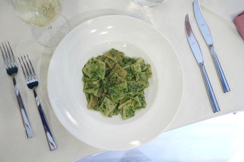 a white plate of food on a table with silverware at Hotel Villa Adriana in Monterosso al Mare