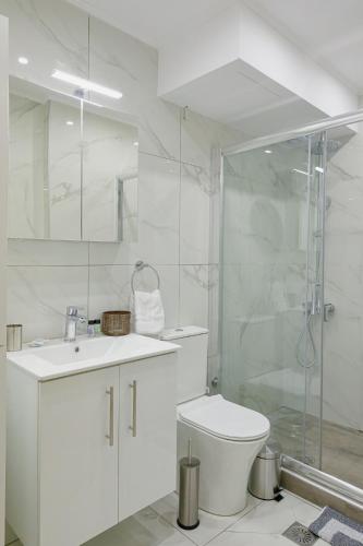 a white bathroom with a toilet and a shower at Ολυμπία in Xanthi