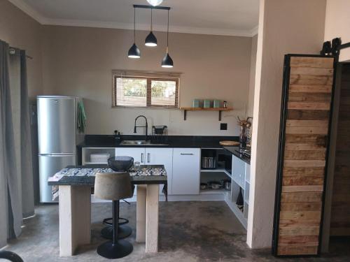 a kitchen with a table and a refrigerator at Cycad Self Catering in Groblersdal