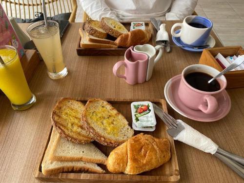 a table with a tray of bread and a cup of coffee at Palacio Balangan Villa in Uluwatu