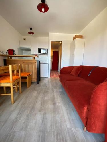 un salon avec un canapé rouge et une cuisine dans l'établissement Chez Olga&Seb, à Huez