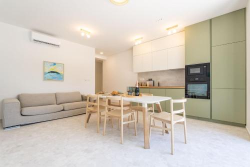 a kitchen and living room with a table and chairs at Apartments Irena in Cavtat