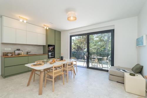 a kitchen and dining room with a table and chairs at Apartments Irena in Cavtat