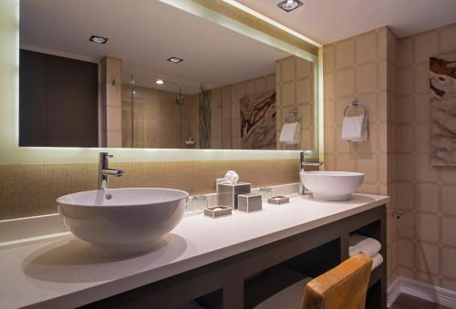 uma casa de banho com 2 lavatórios e um espelho grande em The San Luis Resort Spa & Conference Center em Galveston