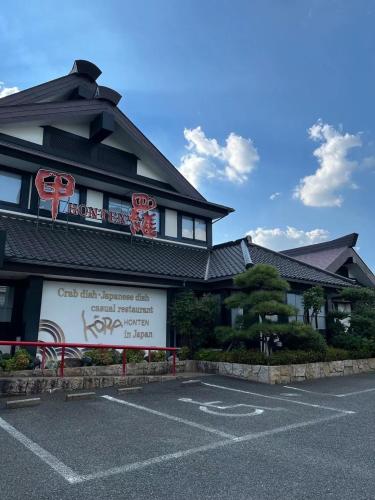 a building with a sign in a parking lot at サンムーン鶴間 in Yamato