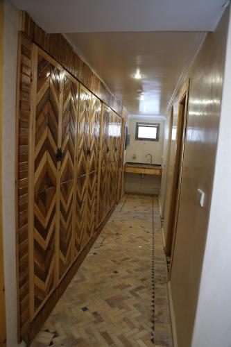 a hallway with wooden doors and a sink in a room at Imsouane WOOD HOUSE in Imsouane