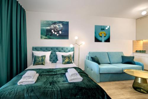 a bedroom with a bed and a blue couch at AboutArtApartments - Otyńska 4 in Wrocław