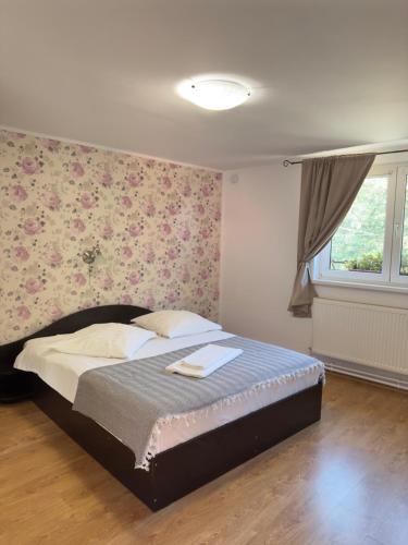 a bedroom with a bed with a floral wall at Marginimea Sibiului - Pensiunea Darian & David in Orlat