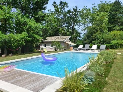 una piscina con un tobogán en un patio trasero en La Plumassière, en Saint-Genis-Laval