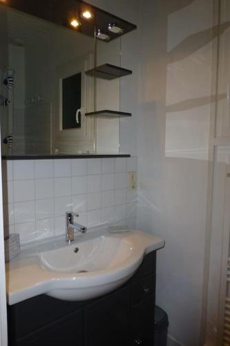 une salle de bain avec un lavabo et un miroir dans l'établissement La Plumassière, à Saint-Genis-Laval