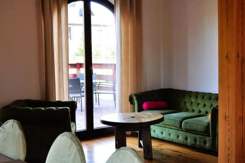 a living room with a green couch and a table at Dom nad Rozlewiskiem in Zamość