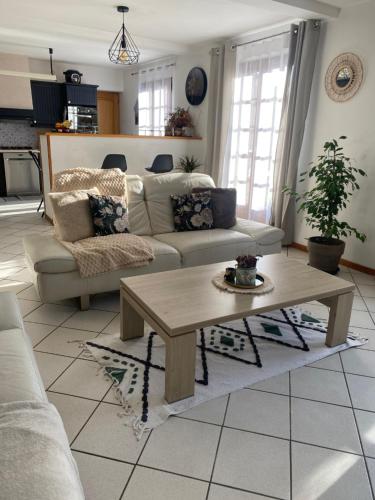 un salon avec un canapé et une table basse dans l'établissement Chambre dans maison près Disneyland Paris - 2, à Brie-Comte-Robert