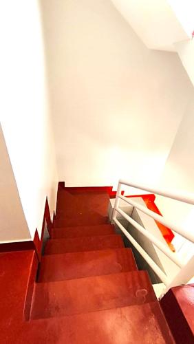 a staircase in a building with red steps and a railing at Uroa Hide Away in Zanzibar City