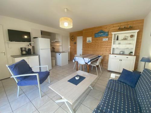 une cuisine et un salon avec une table et des chaises dans l'établissement Appartement de la mer, à Jullouville