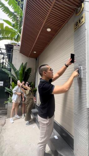 a man holding a camera up to a wall at Cloud House in Hanoi