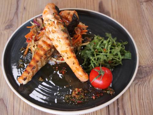 a black plate of food with carrots and a salad at Hotel Junior in Kopaonik