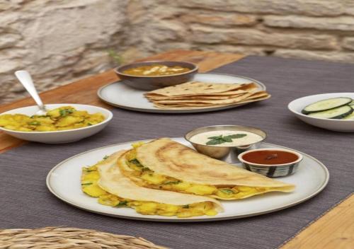 a table with plates of food on a table at Hotel National - Grant Road in Mumbai