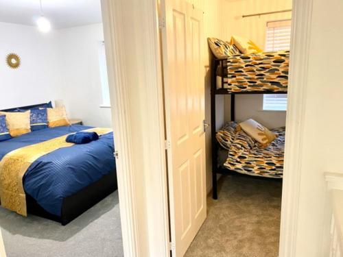 a bedroom with a bed and two bunk beds at 4 Bed House with Driveway Parking for 2 Cars - Rugby - Sleeps 10! in Rugby