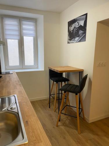 - une cuisine avec une table, 2 chaises et un évier dans l'établissement Apparemment T2 meublé 2bis, à Saint-Symphorien-dʼOzon