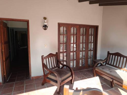 a room with two chairs and a bed and a mirror at Casa entera con jardín en Luque! in San Lorenzo