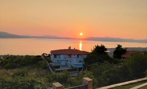 a house on the shore of a lake at sunset at Studio Xanthippe in Kalamos