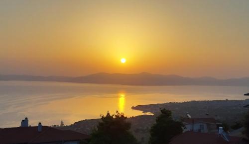 a sunset over the water with the sun in the sky at Studio Xanthippe in Kalamos