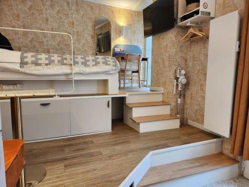 Cette petite chambre comprend des lits superposés et des escaliers. dans l'établissement Cocon déco quartier Antiquaires, à Dijon
