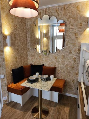 une salle à manger avec une table et un miroir dans l'établissement Cocon déco quartier Antiquaires, à Dijon