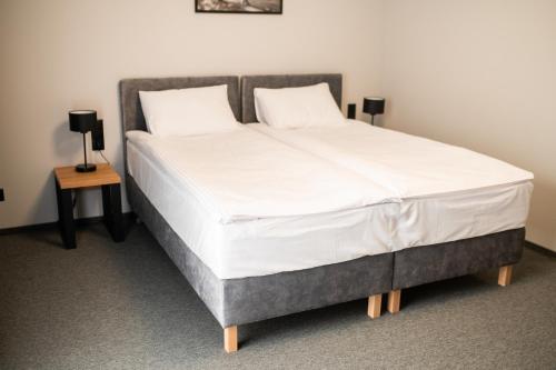 a bed with white sheets and two pillows on it at Hotel Igloo in Krotoszyn