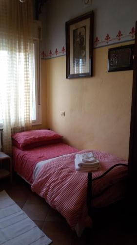 a bedroom with two beds and a table with a picture on the wall at Villa Fiorita in Monfalcone