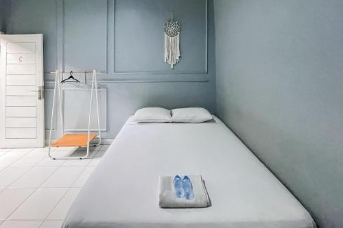 un lit avec deux paires de chaussures bleues dessus dans l'établissement Andung Residence Lampung RedPartner, à Bandar Lampung