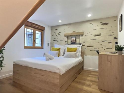 une chambre avec un grand lit et un mur en pierre dans l'établissement Plein centre 8pers 4ch 2sdb, Terrasse, billard Angers ROE, à Angers