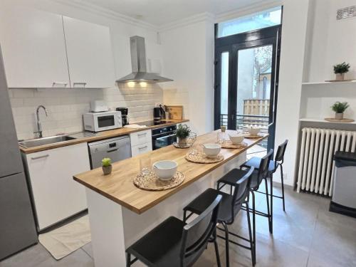 une cuisine avec une longue île dotée d'une table et de chaises dans l'établissement Plein centre 8pers 4ch 2sdb, Terrasse, billard Angers ROE, à Angers