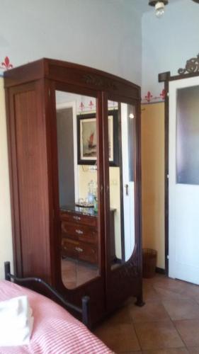 a wooden dresser with a mirror in a bedroom at Villa Fiorita in Monfalcone