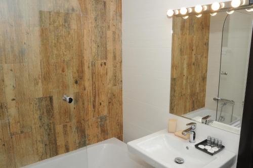 a bathroom with a sink and a shower with a mirror at AS Apartments in Kopaonik